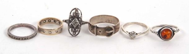 Six rings: to include a 9ct and silver ring, a silver buckle ring, an amber cabochon ring, a white