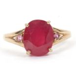 A 9ct ruby and pink stone ring, the central oval ruby in a four claw mount, with a small pink