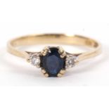 A 9ct sapphire and diamond ring, the oval sapphire set to either side, with plain band with London