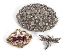 Three brooches: to include an unmarked three stone garnet and yellow metal brooch, (tests as approx.