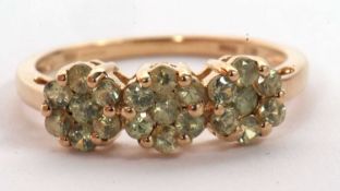 A 9ct demantoid garnet ring, comprised of three clusters of small pale green demantoid garnets, claw