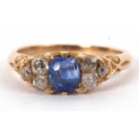 A sapphire and diamond ring, the oval mixed cut sapphire set to either side with three old mine