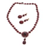 A late 19th century garnet necklace and matched earrings, the necklace set with a central round