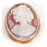 An 18ct mounted oval shell cameo brooch/pendant, carved with a bust of a lady, collet mounted with