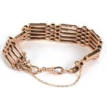 A 9c rose gold gate bracelet, with lobster clasp and safety chain, stamped 9c to one end, 17.0g