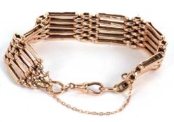 A 9c rose gold gate bracelet, with lobster clasp and safety chain, stamped 9c to one end, 17.0g