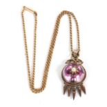 An early 20th century pendant and associated chain, the round pink foil backed rock crystal