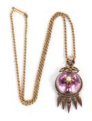 An early 20th century pendant and associated chain, the round pink foil backed rock crystal
