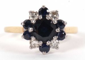 An 18ct sapphire and diamond cluster ring, the central round sapphire surrounded by alternating