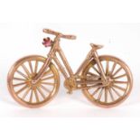 A late 19th/early 20th century 9ct bicycle brooch, set with a small red hardstone, hallmarked to