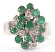An emerald and diamond cluster ring, the asymetric cluster of small round emeralds and diamonds, all