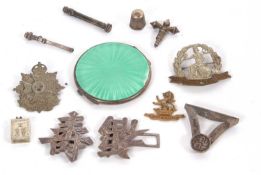 A mixed lot to include a Chinese character buckle, two cap badges, a green enamel compact, etc