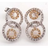 A pair of diamond earrings, comprised of two overlocking circles of small round diamonds set in