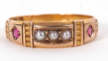 A late 19th century 15ct ring, set to centre with three seed pearls and a small ruby to either side,
