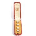 A cased set of four 18ct and mother of pearl buttons, the off-square mother-of-pearl buttons with