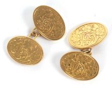 A pair of late Victorian 9ct cufflinks, the oval discs with engraved decoration and chain spacers,