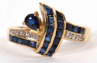 An 18ct sapphire and diamond ring, the crossover style ring set with a pear shape and calibre cut
