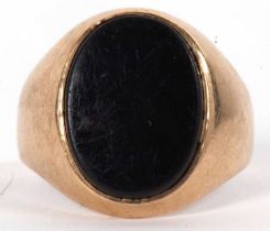 A 9ct black onyx ring, the oval black onyx disc, collet mounted with tapering shoulders and plain