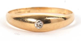 An 18ct single stone diamond ring, the small round diamond set within a 4.5mm wide band, tapering