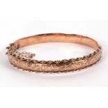 A 9ct hinged bangle, with engraved decoration to upper half with bead and rope twist border, plain