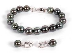 An 18ct cultured grey pearl bracelet and 18kt cultured grey pearl and diamond earrings, the bracelet