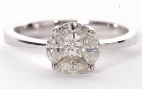 An 18ct white gold and diamond ring, the round diamond head set with a central princess cut
