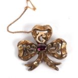 An almandine garnet memorial brooch, the trefoil shaped ribbon brooch, with engraved decoration, set