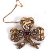An almandine garnet memorial brooch, the trefoil shaped ribbon brooch, with engraved decoration, set
