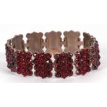 A garnet bracelet, comprised of rectangular panels of garnets, 17mm wide, hinged joints, with hook