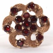 A 9ct garnet cluster ring, with textured looped petals, plain band hallmarked London 1971, size O-P,