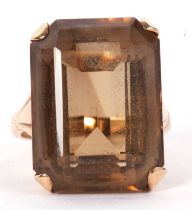 A 9ct smokey quartz ring, the rectangular emerald cut smokey quartz in a four claw mount with
