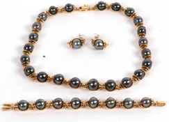 An 18k cultured black pearl suite, comprised of off-round cultured black pearls in cup style