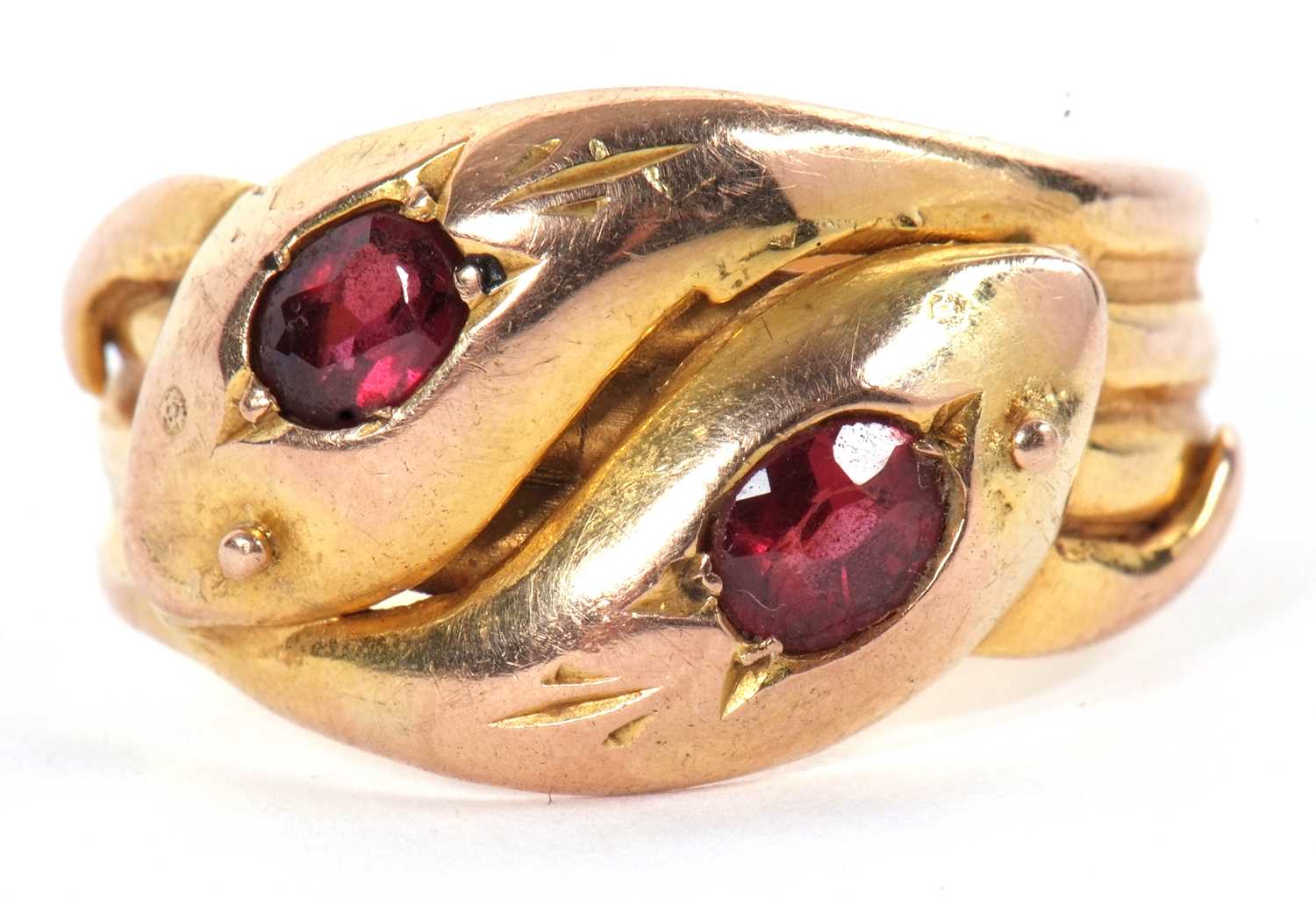 An early 20th century 9ct gemset snake ring, the two snake heads with a red gemstone set to each