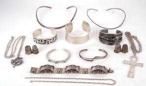 A mixed lot of silver and white metal jewellery to include a tapered silver bangle with hammered