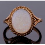 A 9ct opal ring, the oval opal cabochon, approx. 12mm long, collet mounted with rope twist border,