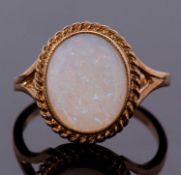 A 9ct opal ring, the oval opal cabochon, approx. 12mm long, collet mounted with rope twist border,