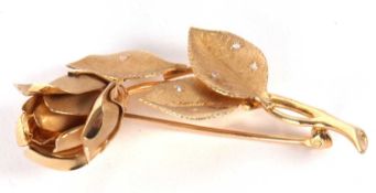 A 14kt and diamond rose brooch, the naturalistically modelled rosebud with satin finish petals,