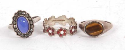 Three silver rings: a red and white enamel 'daisy' ring stamped 'silver', size P; a silver tigers