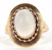 A 14ct moonstone ring, the the oval moonstone cabochon, in a scalloped collet mount with rope
