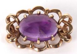 A 9ct amethyst brooch, the oval amethyst cabochon, claw mounted within an overlapping scalloped