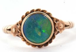 A 9ct opal ring,the round opal cabochon, collet mounted with rope twist border and closed back, 10.