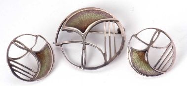 An Art Nouveau style enamelled brooch and matching earrings by Pat Cheney, the round brooch with