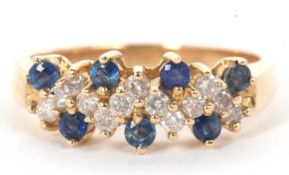 A 14k sapphire and diamond ring, set with a zig-zag style line of small round brilliant cut