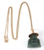 A jadeite buddha pendant and chain, the carved jadeite buddha with unmarked yellow metal hat, 25mm