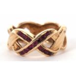 A 14k ruby crossover ring, the two crossover strands set to centre with small round rubies forming a