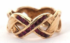 A 14k ruby crossover ring, the two crossover strands set to centre with small round rubies forming a