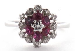 An 18ct ruby and diamond cluster ring, the central small round diamond, surrounded by round rubies