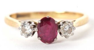 An 18ct and platinum ruby and diamond ring, the central oval ruby, calw mounted with a round