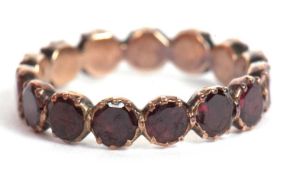 A garnet eternity ring, the full hoop ring set with round garnets, approx. 4mm wide, all in