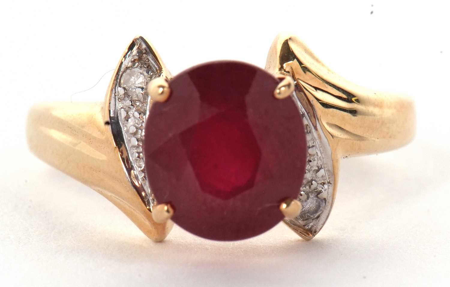 A 14k ruby and diamond ring, round ruby, approx. 8.8mm diameter, in a four claw mount, with a